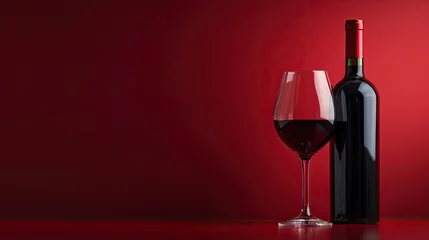 Fotobehang Bottle and glass of red wine on a red background. Copy space. © Sasint