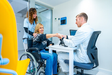Doctor handshaking a mature woman in wheelchair in the hospital