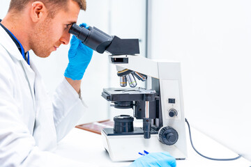 Doctor using microscope to analyze samples in a laboratory