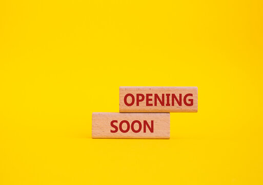 Opening soon symbol. Concept word Opening soon on wooden blocks. Beautiful yellow background. Business and Opening soon concept. Copy space
