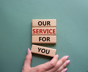 Our service for you symbol. Wooden blocks with words Our service for you. Beautiful grey green background. Businessman hand. Business and Our service for you concept. Copy space.