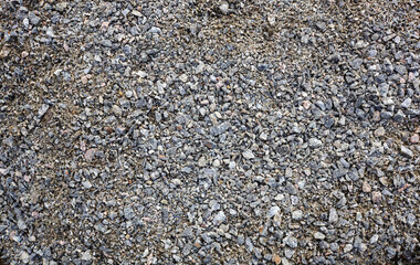 Grey ground stone rubble road background. Natural gray granite chippings, macadam, rubble or crushed stones texture, top view