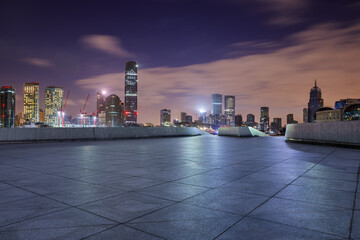Empty square floor and modern city building landscape at night