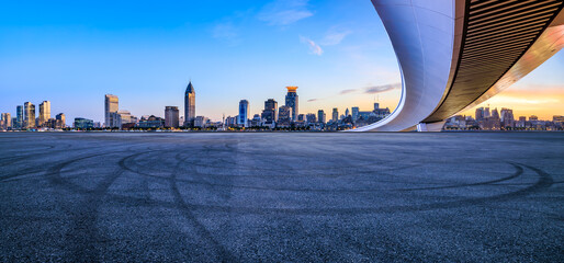 Asphalt road square and bridge with city skyline at sunset in Shanghai