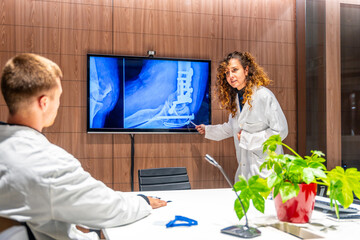 Doctors analysing radiological leg x-ray scan