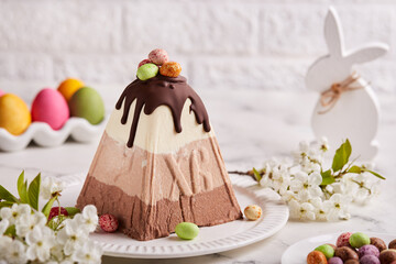 Paskha Cottage cheese traditional Easter dessert with three types of chocolate white, milk and bitter. Decorated with small colorful candies in a shape of Easter eggs. 