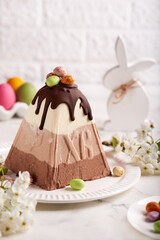 Paskha Cottage cheese traditional Easter dessert with three types of chocolate white, milk and bitter. Decorated with small colorful candies in a shape of Easter eggs. 