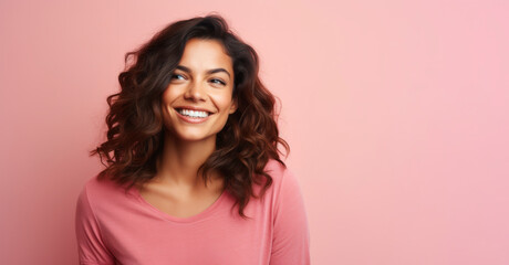 Portrait of happy smiling young woman in pink sweater over pink background.
