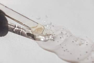 Close up of transparent serum or oil glass mock up on bottle on light background