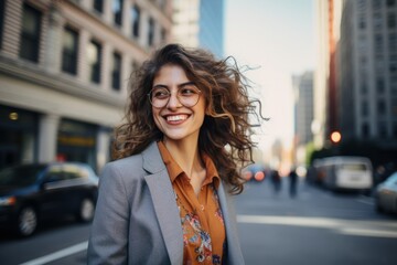 Fototapeta premium A sophisticated woman in a stylish denim blazer, confidently walking down a bustling city street, her radiant smile reflecting the vibrant energy of the urban landscape