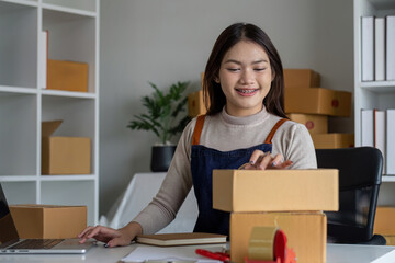 SME entrepreneur small business online sales concept, happy Asian business owner working on...