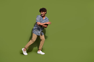 Full body size photo of young arabian man chilling dynamic moves dancing after long day in office isolated on khaki color background