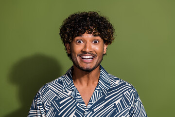Closeup portrait photo of young amazed arabian funny guy in shirt toothy beaming smile surprised isolated on khaki color background