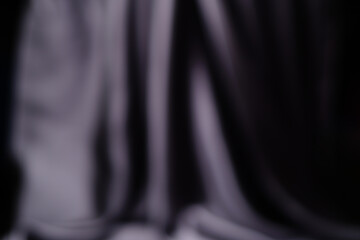 The backdrop is a gray-black satin fabric, a dark, shiny fabric, an abstract silk with a beautiful...