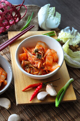 Top view of Korean Kimchi Bowl with Fresh Ingredients on Wooden Board