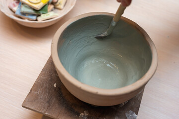 Clay, ceramics or hands in a design workshop working on an artistic cup or mug. The hand of a creative artist or worker making crafts in sculpture