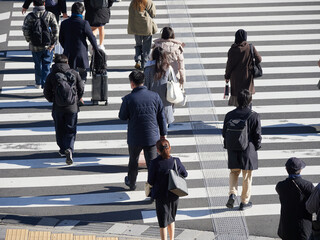 冬の都市の交差点の横断歩道を渡る人々の姿