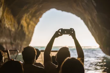 Photo sur Plexiglas Plage de Marinha, Algarve, Portugal Tourist sightseeing and taking photos with smartphones inside the cave on Algarve coast, Albufeira, Portugal