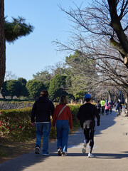 Fototapeta premium 冬の東京の皇居外苑の道でランニングする人々の姿