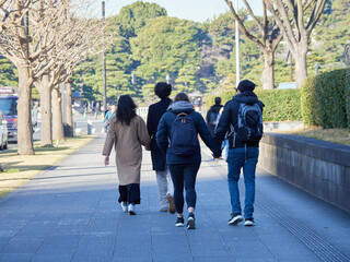 冬の東京都の皇居外苑の道で歩く外国人観光客の姿 - obrazy, fototapety, plakaty