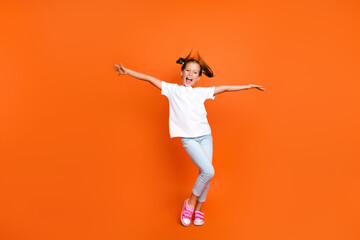 Full length portrait of small overjoyed schoolchild raise hands throw hair dancing isolated on...