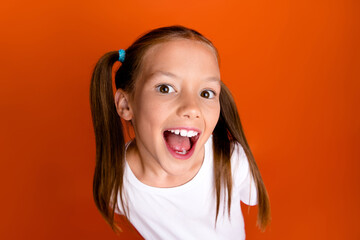 Portrait of funky astonished girl open mouth interested listen eavesdrop isolated on orange color...