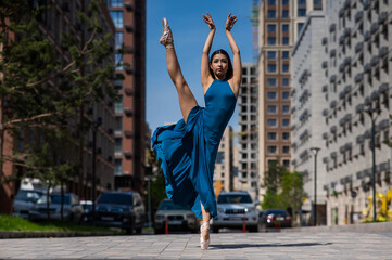Fototapeta na wymiar Beautiful Asian ballerina dancing outdoors. Urban landscape.