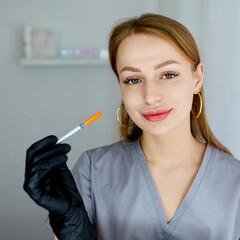 Portrait of a cosmetologist in the office with a syringe. Injection procedure for lip augmentation....