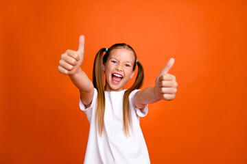 Photo portrait of cute little lady thumb up excited good job rate quality wear trendy white garment isolated on orange color background - obrazy, fototapety, plakaty