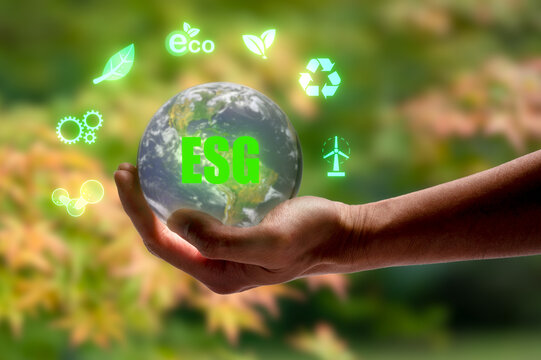 hand holding crystal ball ESG concept. Environment society and governance sustainable business on blurred autumn background multi exposure, Elements of this image furnished by NASA