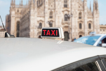 Taxi in Milan, Italy. Italian white taxi with sing on the roof. - obrazy, fototapety, plakaty
