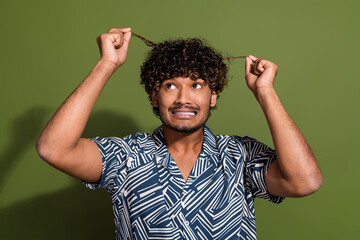 Photo of impressed unhappy guy wear print shirt dislike hairdo curls isolated khaki color background