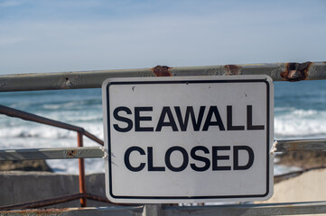 Seawall closed sign on a beach