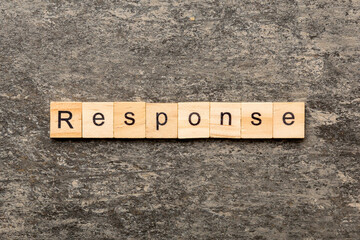 RESPONSE word written on wood block. RESPONSE text on cement table for your desing, concept