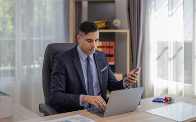 Male manager in suit multitask on laptop, tablet in modern office, talk to clients, analyze project