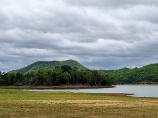 The landscape of the mountain and the reservoir on nimbus clouds in the sky background