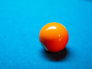 Closeup of colorful billiard balls on blue pool table in daylight

