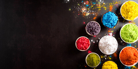 Happy Holi decoration, the indian festival.Top view of colorful holi powder on dark stone background.