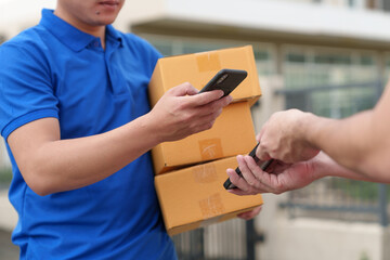 Delivery worker, SME entrepreneur, online sales concept, delivery, SME parcel box, procurement, delivery, customer holds the parcel box and scans to pay online application on mobile phone at home. - obrazy, fototapety, plakaty