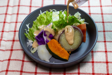 ドレッシングをかけたお皿に盛り付けた蒸し野菜のサラダ