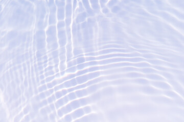 Bluewater waves on the surface ripples blurred. Defocus blurred transparent blue colored clear calm water surface texture with splash and bubbles. Water waves with shining pattern texture background.