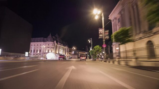 Point of view driving a car through Bucharest city centre at night. First person view passing cars on the street