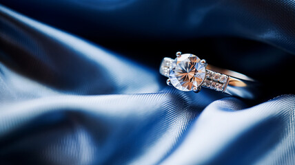 Jewellery, proposal and holiday gift, diamond engagement ring on blue silk fabric, symbol of love, romance and commitment