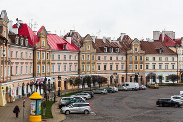 Lublin, Poland - 25 December 2019: Colorful houses in the beautiful old city of Lublin at Christmas and cars on the parking lot - obrazy, fototapety, plakaty