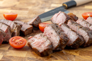 A steak on a cutting board with herbs and spices.Grilled beef tenderloin steak on a wooden board with grilled vegetables. Filet Mignon recipe concept, selective focus