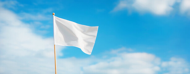 white flag on a wooden stick, fluttering in the wind, against a clear blue sky. place to copy