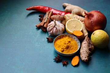 Ginger, lemon, turmeric, cinnamon sticks, anise star, garlic bulb, horseradish on a blue background...