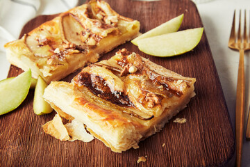 Handmade close up mini tarts with puff pastry, pieces of pears, camembert, walnuts and honey.