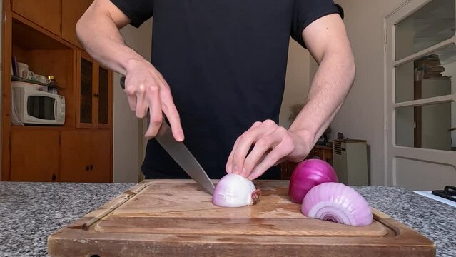 Cook cutting red onion into small cubes, brunoise cut. Cooking at home.