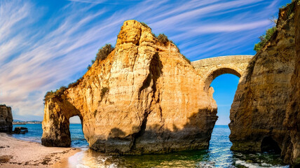 Panoramic Limestone Cliff Archway with Historic Stone Bridge on Serene Mediterranean Coastline